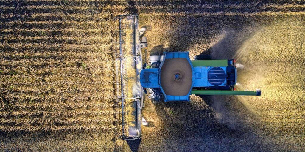 Autonomous Farming Machinery such as driverless tractors and drones operating in a modern smart agriculture field.