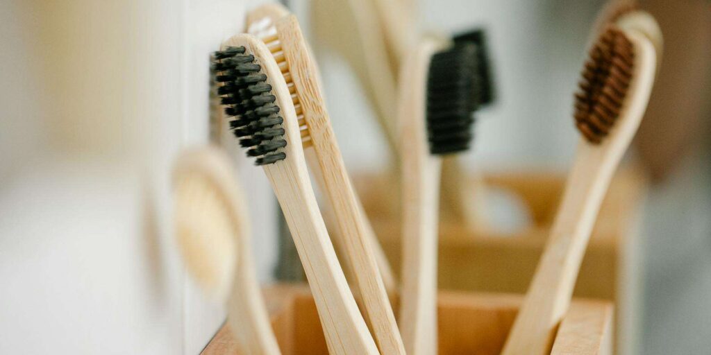 Eco-friendly bamboo toothbrush placed beside natural leaves promoting a plastic-free sustainable lifestyle.