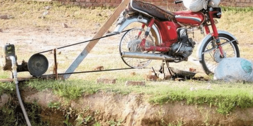 Indian farmer using innovative low-cost jugaad tools in agriculture, including a bicycle sprayer and homemade tiller in a green farm field.