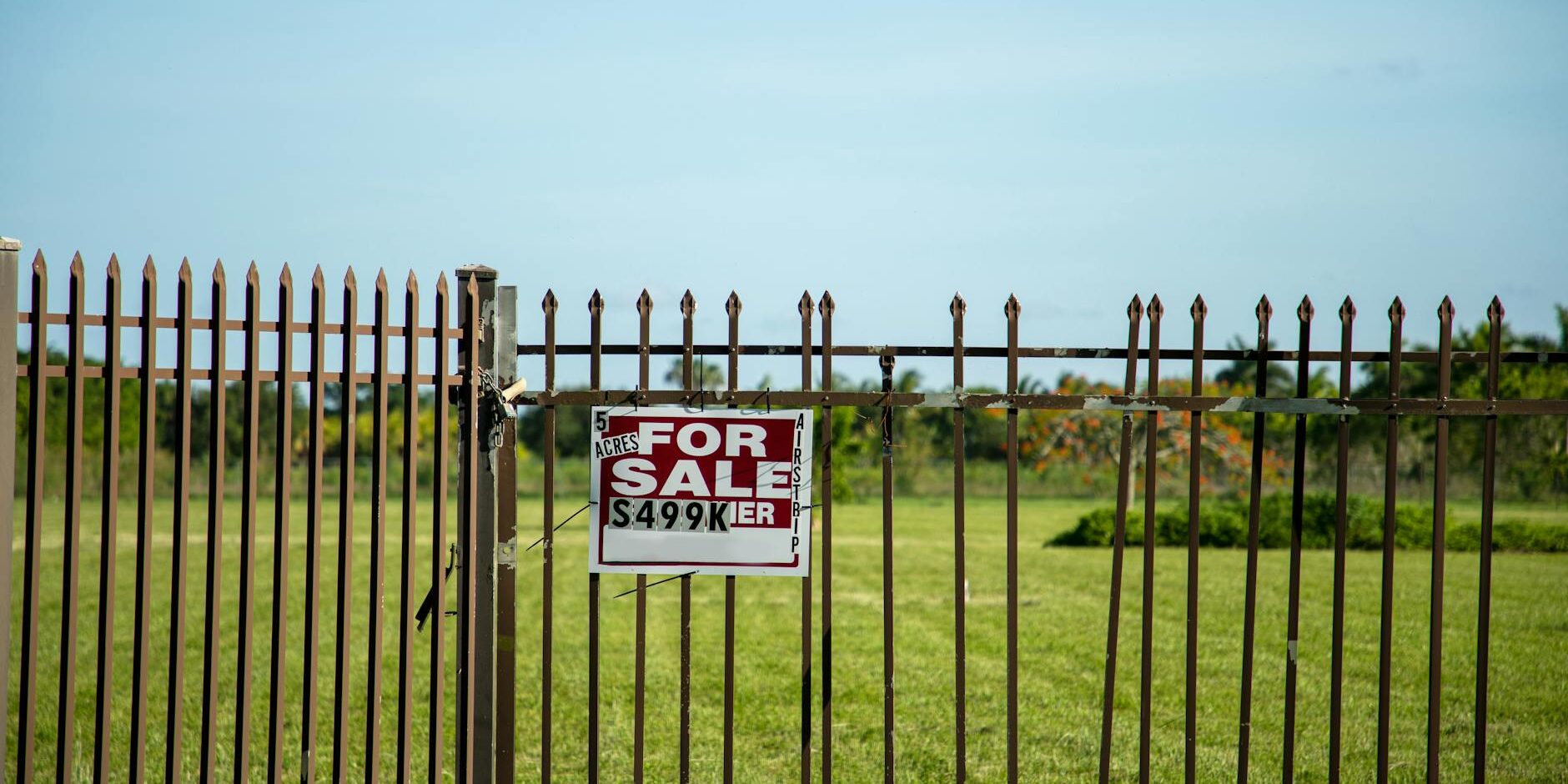 fenced plot of land with for sale sign